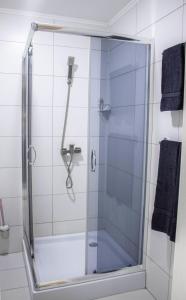 um chuveiro com uma porta de vidro na casa de banho em Готельно-ресторанний комплекс Фамілія em Bushtyno