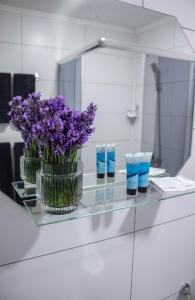a glass counter with purple flowers in a mirror at Готельно-ресторанний комплекс Фамілія in Bushtyno