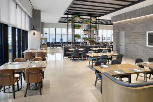 a dining room with tables and chairs and windows at Four Points by Sheraton Josun, Seoul Myeongdong in Seoul