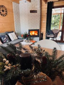 a living room with a table with trees and a fireplace at Domek na Słonecznym Pagórku in Baligród