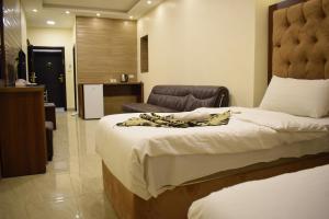 una camera con un grande letto e una sedia di Nour Hotel ad Amman