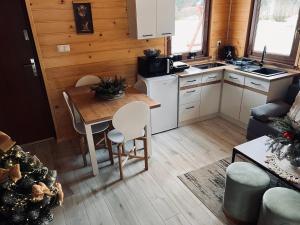 a kitchen with a table and chairs in a tiny house at Domek na Słonecznym Pagórku in Baligród
