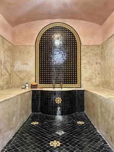 ein Bad mit Dusche und schwarzem Fliesenboden in der Unterkunft Villa pied lac, jet ski, quad, piscine, internet in Marrakesch