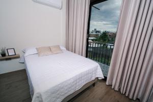 een slaapkamer met een bed en een balkon met een raam bij CASA MONA 3 - Apartamento en Tarapoto in Tarapoto