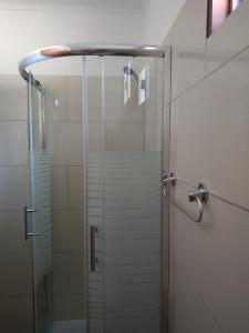 y baño con ducha y puerta de cristal. en Techos Amarillos aparthotel en Fomento