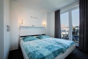 - une chambre avec un lit et un balcon dans l'établissement Penthouse "Ostsee-Himmelreich" Großenbrode, à Großenbrode