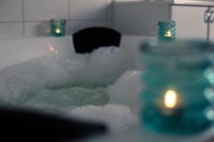 una vasca da bagno piena di neve e di una candela di Penthouse "Ostsee-Himmelreich" Großenbrode a Grossenbrode