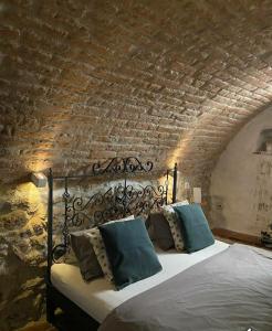 a bedroom with a bed with a brick wall at Apartmany Antico in Mikulov