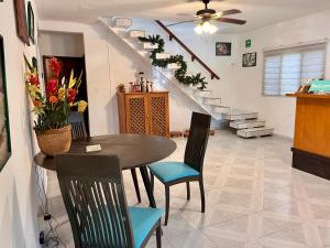 uma sala de jantar com mesa, cadeiras e escadas em Casa Puerto Morelos em Puerto Morelos