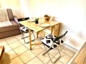 - une table et des chaises en bois dans le salon dans l'établissement Studio entre Aix en Provence et Marseille et parking, à Septèmes-les-Vallons
