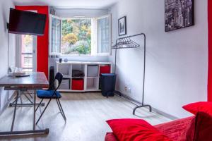 uma sala de estar com um sofá, uma mesa e uma secretária em Mon petit nid à Amélie em Amélie-les-Bains-Palalda
