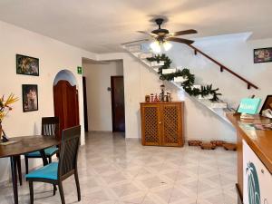 uma sala de estar com uma escada e uma mesa e cadeiras em Casa Puerto Morelos em Puerto Morelos