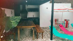 a kitchen with a table and chairs and an umbrella at Praia Piscina Bilhar Churrasqueira in São Sebastião