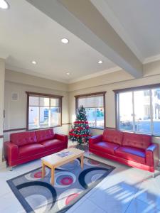 a living room with two red couches and a christmas tree at Ramada by Wyndham in Quesnel