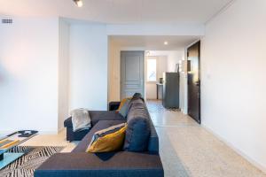a living room with a blue couch and a refrigerator at 034- Tropisme, Appart 2 chambres, Clim, Wifi, Parking in Montpellier