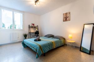 a bedroom with a bed and a large window at 034- Tropisme, Appart 2 chambres, Clim, Wifi, Parking in Montpellier