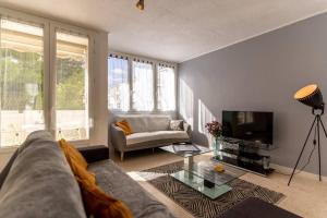 a living room with a couch and a tv at 034- Tropisme, Appart 2 chambres, Clim, Wifi, Parking in Montpellier