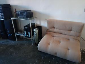 a brown chair sitting in a room with a tv at Quarto e banheiro particular in Taboão da Serra