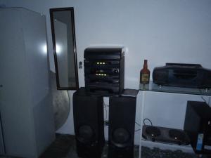 a room with a stereo system and a microwave at Quarto e banheiro particular in Taboão da Serra