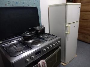 a stove with two pots on it next to a refrigerator at Pensao do Viajante in Chimoio