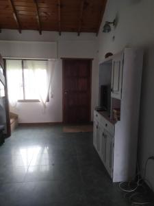 an empty living room with a television and a window at Casa Chalet Lamar alojamiento entero in Santa Clara del Mar