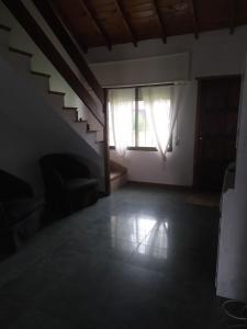 a living room with a staircase and a window at Casa Chalet Lamar alojamiento entero in Santa Clara del Mar