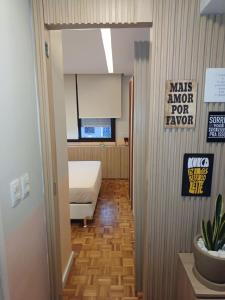 a hallway with a room with a bed and a sign at Angi Hosting in Porto Alegre