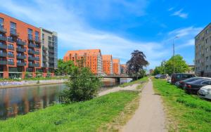 un chemin de terre à côté d'une rivière avec des bâtiments dans l'établissement Old Town Blue - Dobra, à Gdańsk