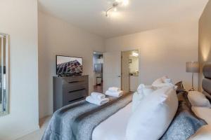 um quarto com uma cama com almofadas e uma televisão em Enjoy a Cozy 3 BR/Clubhouse/Near Disney and more em Kissimmee