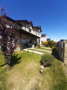 a house with a fence in the yard at Posada Alma del Cerro in El Calafate