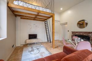 - un salon avec un canapé et une cheminée dans l'établissement Le poudré Cours Fauriel magnifique appartement, à Saint-Étienne