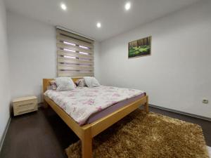 ein Schlafzimmer mit einem Bett in einem weißen Zimmer in der Unterkunft Stan SK in Pale