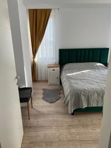 Un dormitorio con una cama y una silla y una ventana. en Narci Home, en Craiova