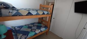 1 dormitorio con 2 literas y TV en Departamento 3 dormitorios, 1 baño y 2 valcones, en Arica