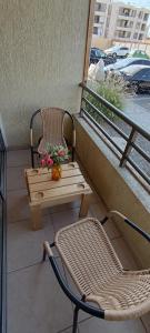 balcón con mesa, silla y banco en Departamento 3 dormitorios, 1 baño y 2 valcones, en Arica