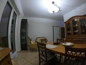 uma sala de jantar com uma mesa de madeira e cadeiras em Casa Rossi em Pomigliano dʼArco