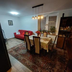ein Wohnzimmer mit einem Tisch und einem roten Sofa in der Unterkunft Sunstreet in Lubin