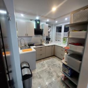 una cocina con armarios blancos y fregadero en Sunstreet, en Lubin