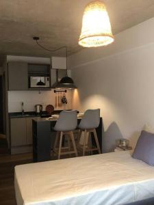a bedroom with a bed and a kitchen with a table at Casi a nuevo, moderno y bien ubicado in Montevideo