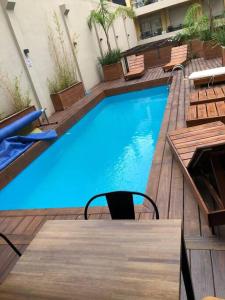 een groot blauw zwembad met een tafel en stoelen bij Casi a nuevo, moderno y bien ubicado in Montevideo
