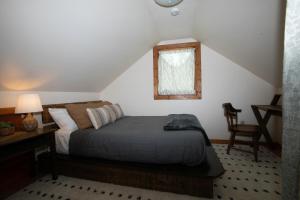 Cozy Tiny Haus Apt في Torrington: غرفة نوم بسرير ومكتب ونافذة