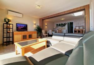 a living room with couches and a table and a tv at Lloret Paradise Apartments in Lloret de Mar