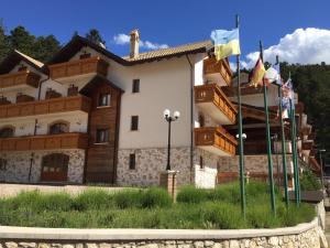 a large house with flags in front of it at HOTEL MILLE PINI in Ovindoli