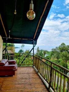 a porch with a couch on a wooden deck at Mzinga Retreat in Gitesi