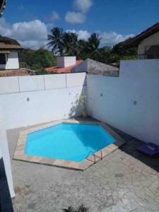 una grande piscina blu accanto a un muro bianco di Casa de Praia Buraco da velha a Lauro de Freitas