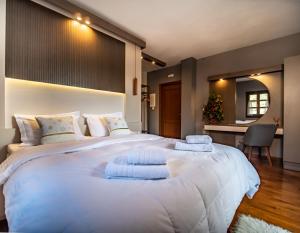a bedroom with a large white bed with pillows at Erofili Hotel & Suites in Portaria