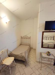 オストゥーニにあるBed & Breakfast dei Colliのベッドルーム1室(ベッド1台、椅子、鏡付)