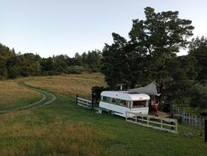 a camper parked in a field with a tent at Down to earth NZ in Kerikeri