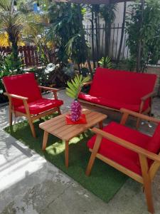 due sedie e una panchina e un tavolo sull'erba di Hostal Hansi a Bocas del Toro