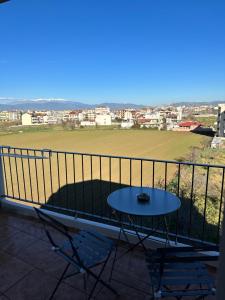 a table and chairs on a balcony with a field at Νεάπολη in Larisa